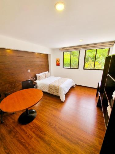 a bedroom with a bed and a table at Burbi Lake Lodge Monteverde in Monteverde Costa Rica