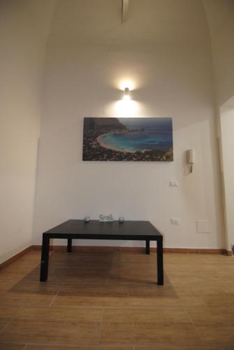 uma mesa num quarto com um quadro na parede em Casa Cinisi - Casa Vacanze em Cinisi