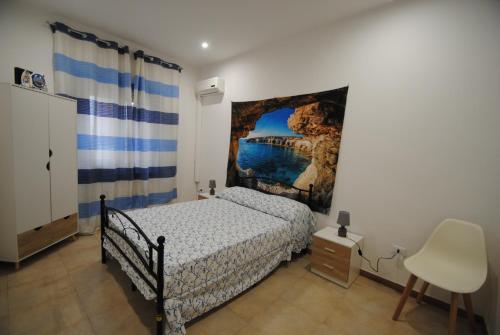 ein Schlafzimmer mit einem Bett und einem Wandgemälde in der Unterkunft Casa Cinisi - Casa Vacanze in Cinisi