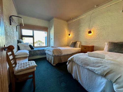 a hotel room with two beds and a window at Snow Gums 16, alpine-getaways in Dinner Plain