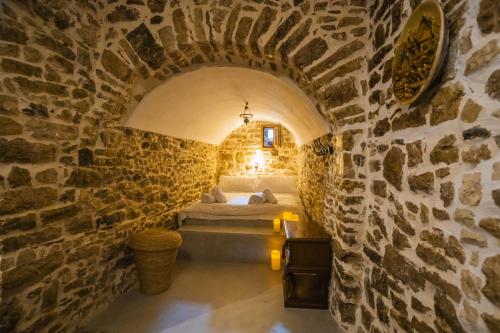 a bedroom with a bed in a stone wall at Villa Porta Qeparo in Qeparo