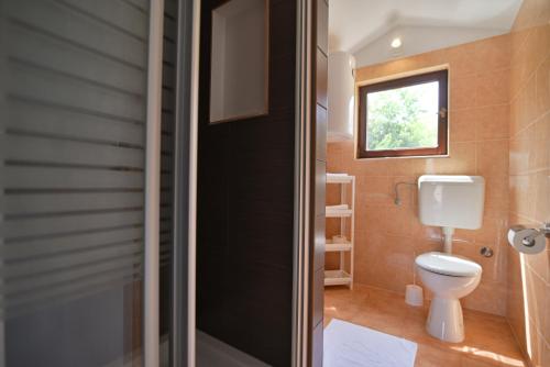 a bathroom with a toilet and a window at Guesthouse Kate in Trogir