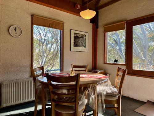 a dining room with a table and chairs and a clock at Snow Gums 16, alpine-getaways in Dinner Plain