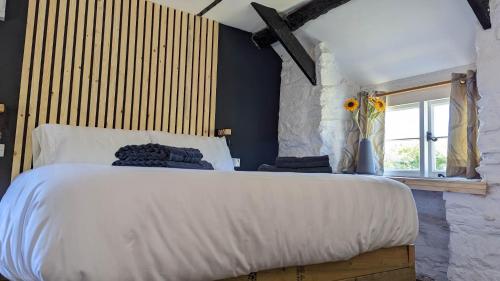 a bedroom with a large white bed and a window at Romantic Hideaway in Trawsfynydd