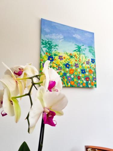 a painting of flowers in a vase on a wall at Burbi Lake Lodge Monteverde in Monteverde Costa Rica