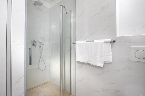 a shower with a glass door in a bathroom at Apartman Palma and Luxury Penthouse for a family with swiming pool,parking,terrace,panoramic view at the sea,Podstrana in Podstrana