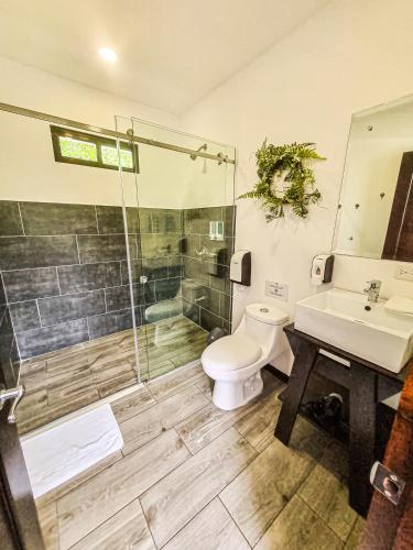 a bathroom with a shower and a toilet and a sink at Burbi Lake Lodge Monteverde in Monteverde Costa Rica
