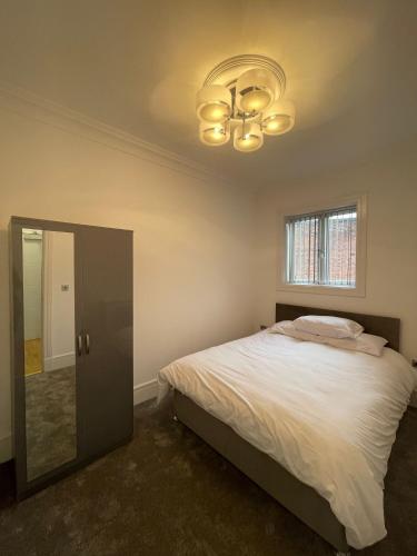 a bedroom with a bed and a chandelier at Luxury Apartment APT5 in Wolverhampton