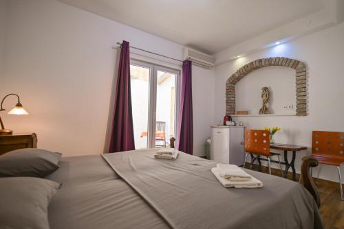 Schlafzimmer mit einem Bett, einem Tisch und einem Fenster in der Unterkunft Guesthouse Kate in Trogir