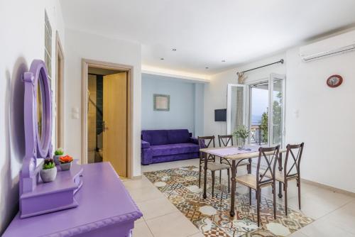 a living room with a table and chairs and a purple couch at Elios Cozy Apartment in Neo Klima