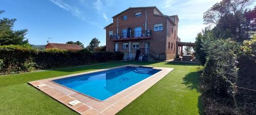 a large swimming pool in front of a house at Bravaholidays-601-Lloret Park 1 in Vidreres