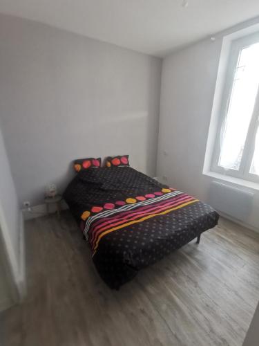 a bed in a room with two windows at Appartement avec terrasse in Vichy