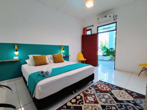 ein Schlafzimmer mit einem großen Bett und einer Wand mit grünen Akzenten in der Unterkunft Bona Vida Hostel in Ríohacha