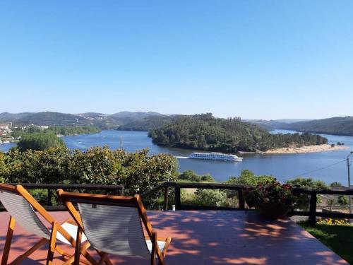 two chairs sitting on a patio with a view of a river at Douro Charming Chalet in Melres