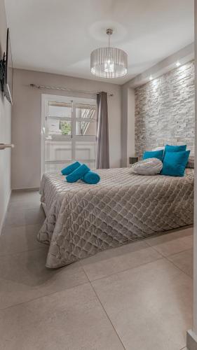 a bedroom with a large bed with blue pillows at Apartment Orlando in Adeje