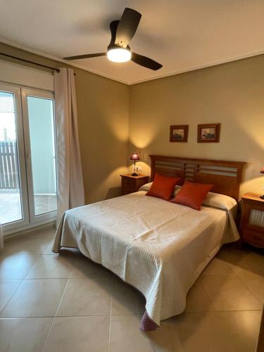- une chambre avec un lit et un ventilateur de plafond dans l'établissement APARTAMENTO DE LUJO EN PLANTA BAJA CON PISCINA EN LA TORRE GoLF RESORT, à Roldán