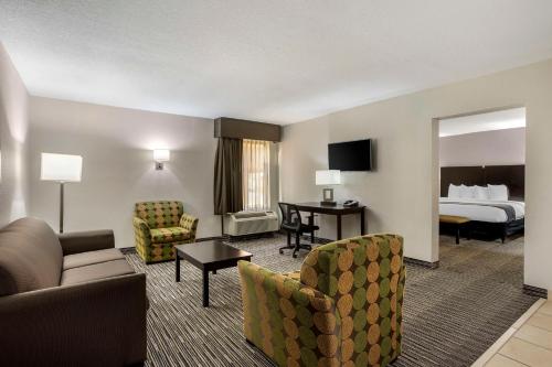 a hotel room with a bed and a living room at Best Western Plus Jonesboro Inn & Suites in Jonesboro