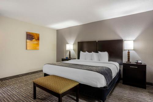 a hotel room with a large bed and a chair at Best Western Plus- Jonesboro in Jonesboro