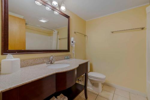 a bathroom with a sink and a toilet and a mirror at Best Western of Lake George in Lake George