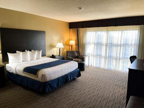 um quarto de hotel com uma cama grande e uma cadeira em Best Western New Albany em New Albany