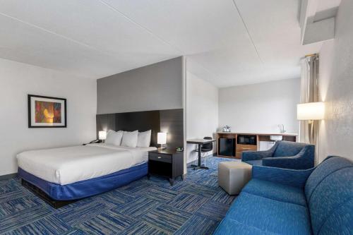 Habitación de hotel con cama y sofá azul en Allentown Park Hotel, Ascend Hotel Collection, en Allentown