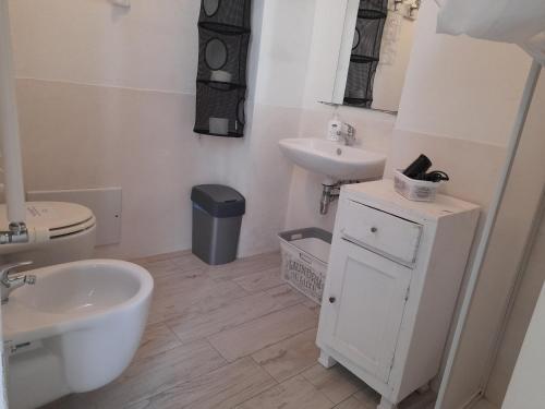 bagno bianco con lavandino e servizi igienici di Dimora Bianca a Cisternino