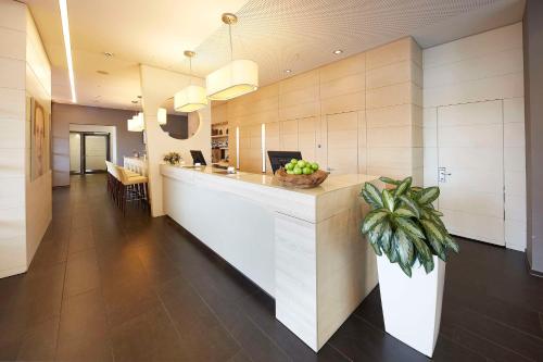 eine Küche mit einer Theke und einer Topfpflanze in der Unterkunft GHOTEL hotel & living Koblenz in Koblenz