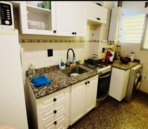 eine kleine Küche mit einer Spüle und einem Herd in der Unterkunft Departamento Güemes in Mar del Plata