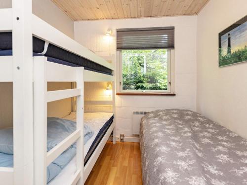 a bedroom with two bunk beds and a window at Two-Bedroom Holiday home in Thyholm 4 in Sindrup