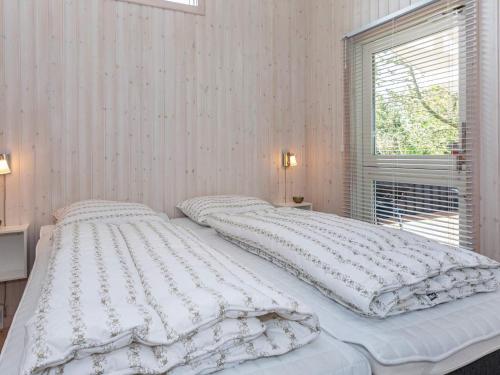 a white bed in a room with a window at 7 person holiday home in Løgstør-By Traum in Løgsted