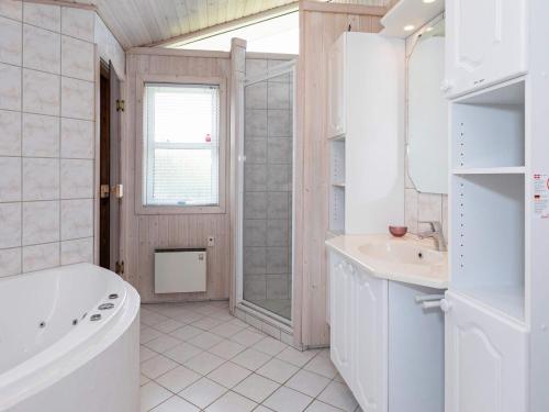 uma casa de banho branca com uma banheira e um lavatório em Holiday home Løgstør XXIV em Løgsted