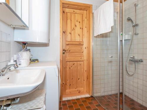 a bathroom with a sink and a wooden door at Holiday home Aars II in Års