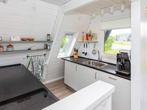 a kitchen in a tiny house with a sink and a window at Golf & Spa Retreat - By Traum Ferienwohnungen in Farsø