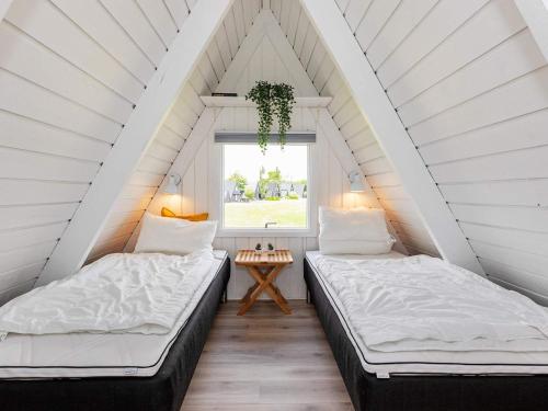 two beds in a attic bedroom with a window at Holiday home Farsø XXIII in Farsø