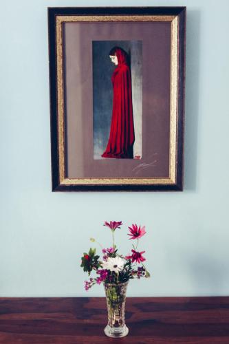a picture of a woman in a red dress with flowers in a vase at Blu Bosa in Bosa