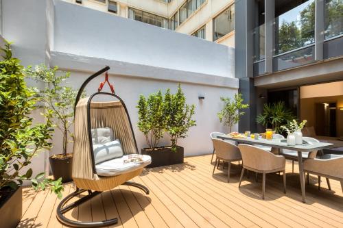 a patio with a hammock and a table and chairs at ULIV Parque Lincoln in Mexico City