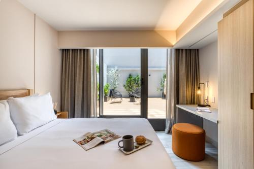 a hotel room with a bed and a view of a patio at ULIV Parque Lincoln in Mexico City