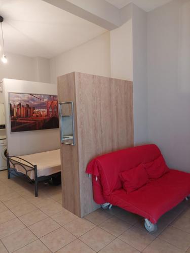 um quarto com um sofá vermelho e uma cama em Soufis house em Igoumenitsa