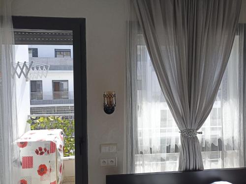 a living room with a window with curtains at La Gironde - Sweet Home - Casablanca in Casablanca