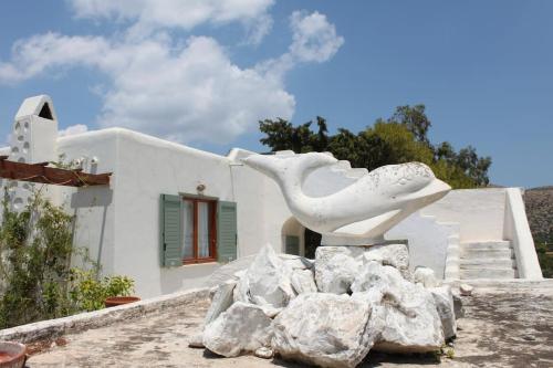 a statue of a bird sitting on top of rocks at Aegean traditional home in Athens Riviera in Sounio