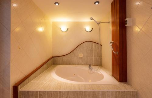 a bath tub in a bathroom with lights on the wall at Hotel Country Trujillo in Trujillo