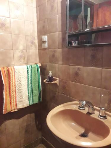 y baño con lavabo, espejo y toallas. en La Casa De Lili en San Salvador de Jujuy