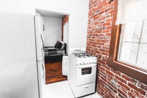 a kitchen with a stove and a brick wall at Flower Apartments in Los Angeles