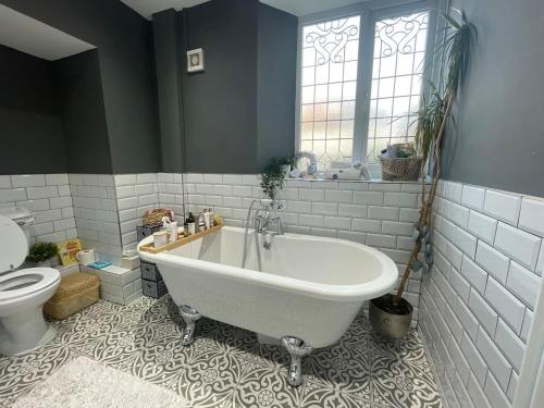 a bathroom with a white tub and a toilet at 1 Bedroom Sea side luxury in New Brighton
