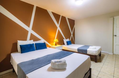 a hotel room with two beds with blue and white at Hotel Country Trujillo in Trujillo