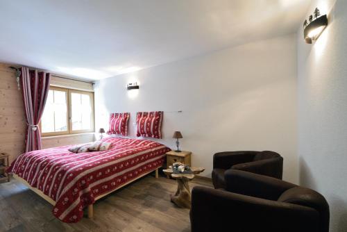 um quarto com uma cama, uma cadeira e uma janela em Hotel Les Mélèzes em Haudères