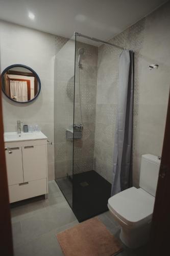 ein Badezimmer mit Dusche, Toilette und Waschbecken in der Unterkunft FURAHA in Villanueva del Fresno