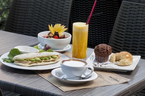 a table with plates of food and a cup of coffee at Hotel Regal Pacific Santiago in Santiago