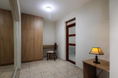 a room with a desk and a lamp on a table at Hotel Country Trujillo in Trujillo