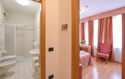 een badkamer met een roze stoel en een wastafel bij 3 Bedroom Stunning Apartment In Roncegno Terme in Marter di Roncegno